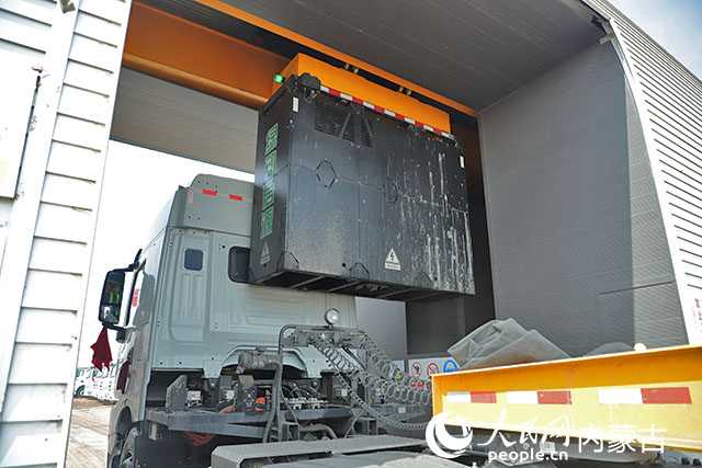 萬利新能源數(shù)字陸港里，正在充換電站進行換電的重卡。人民網(wǎng)記者 趙夢月攝