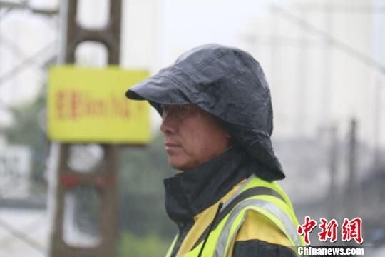 蘭州西工務(wù)段蘭州線路車間防護(hù)員雨中巡查?！⊥豕廨x 攝