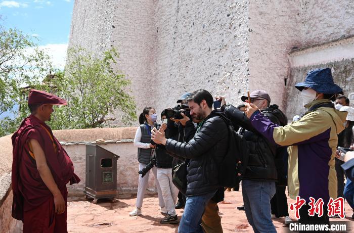 圖為中外媒體拍攝朝拜布達拉宮的僧人?！≮w朗 攝