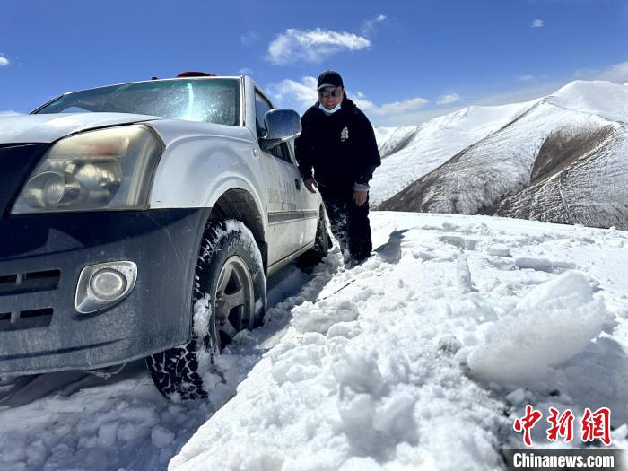 圖為生態(tài)管護人員準備在雪地推車?！《“瓦_杰 攝