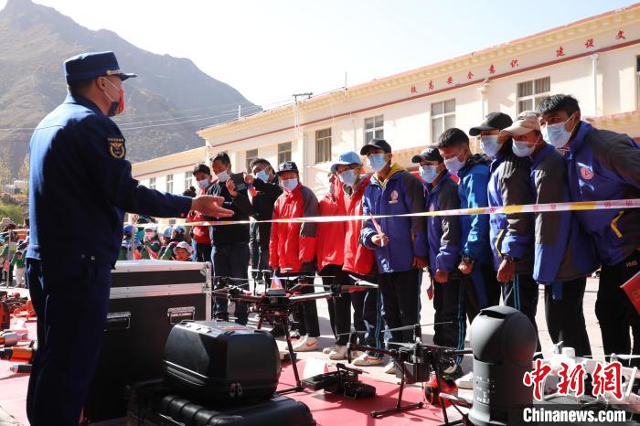 圖為消防指戰(zhàn)員為學(xué)生講解、演示先進(jìn)救援裝備?！≮w琳 攝