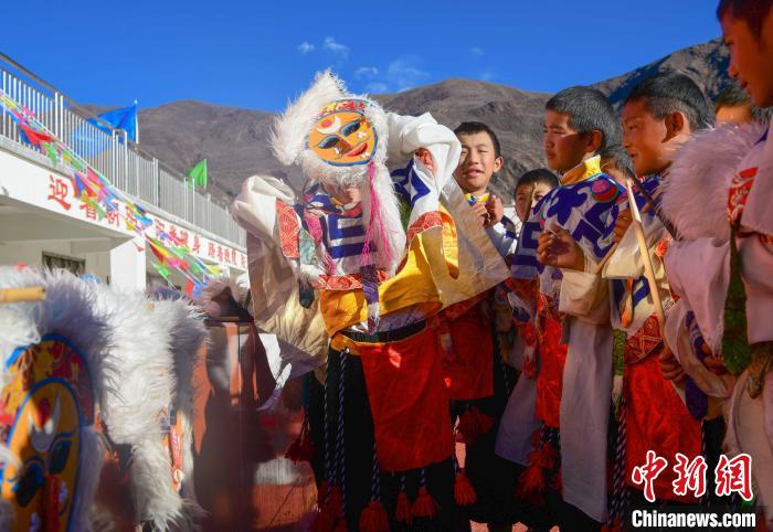 圖為加查縣安繞鎮(zhèn)小學(xué)學(xué)生在試穿藏戲面具?！∝暩聛?lái)松 攝