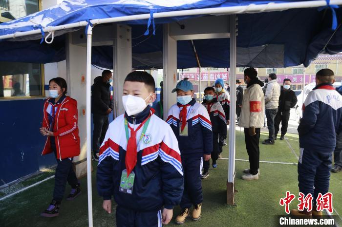 圖為學(xué)生測(cè)量體溫后進(jìn)入校園?！●R銘言 攝