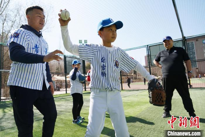 圖為教練指導小棒球手擲球技術?！●R銘言 攝