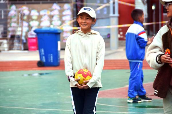 在高原上教孩子們打手球，“慢慢兒來(lái)，甭著急！”