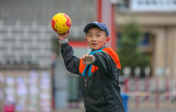 在高原上教孩子們打手球，“慢慢兒來(lái)，甭著急！”