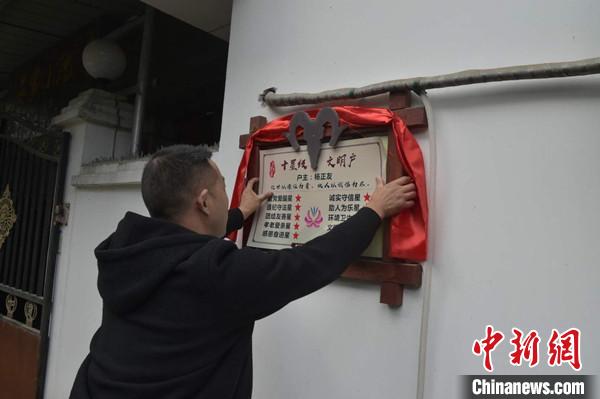 桂溪鎮(zhèn)渭溝村政府工作人員為“十星級(jí)文明戶”掛上牌匾?！钣?攝