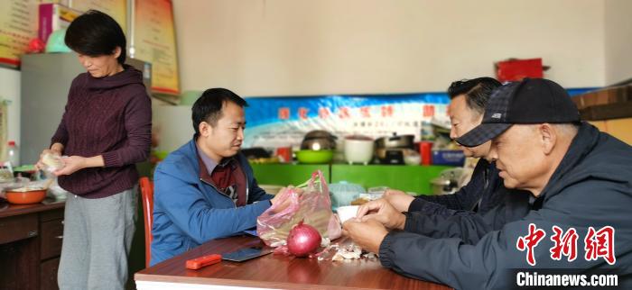 圖為扶貧路上“臨時一家人”準(zhǔn)備午餐?！∥航ㄜ?攝