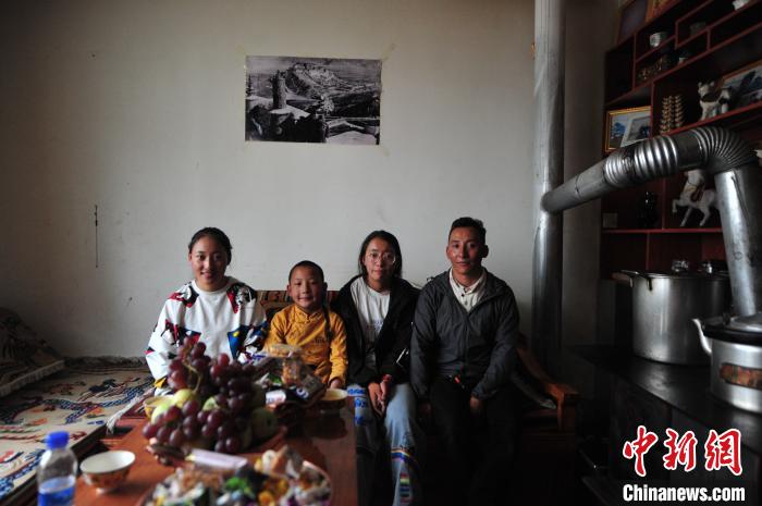 圖為8月12日，2018年7月從距那曲市色尼區(qū)城區(qū)那曲鎮(zhèn)90千米外的古露鎮(zhèn)當(dāng)桑村搬遷至城區(qū)的旦增(右一)與家人在80多平方米的新家合影(資料圖)。　張偉 攝