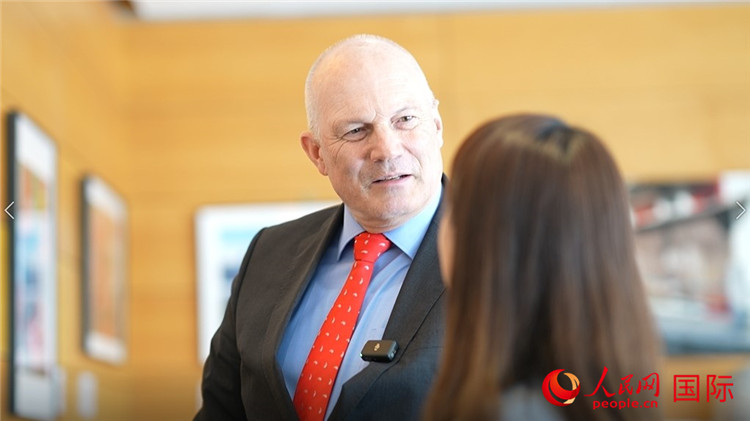 瑞士駐華大使白瑞誼介紹使館內陳列的照片。人民網(wǎng) 彭昱凱攝