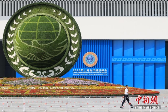 8月31日，天津，一名工作人員從2025年上海合作組織峰會主會場外的景觀花壇旁經(jīng)過。當日，2025年上海合作組織峰會在天津舉行。<a target='_blank' href='/'><p  align=