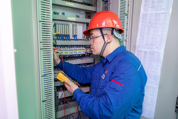 呂曉勇在保護(hù)盤柜前檢查二次回路接線情況。受訪者供圖