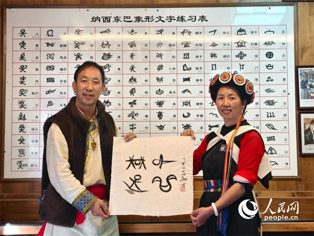 人民網(wǎng)“行進(jìn)中國”云南調(diào)研采訪團(tuán)走進(jìn)麗江，和閏元現(xiàn)場用東巴文寫下“行進(jìn)中國”。人民網(wǎng)記者 符皓攝