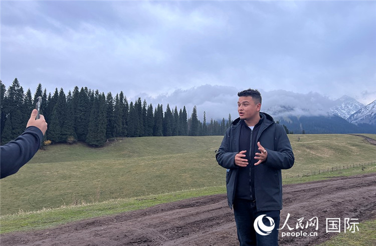 在庫爾德寧，吾買爾江被雪山美景震撼，即興錄制了短視頻作品。人民網(wǎng)記者曾書柔攝