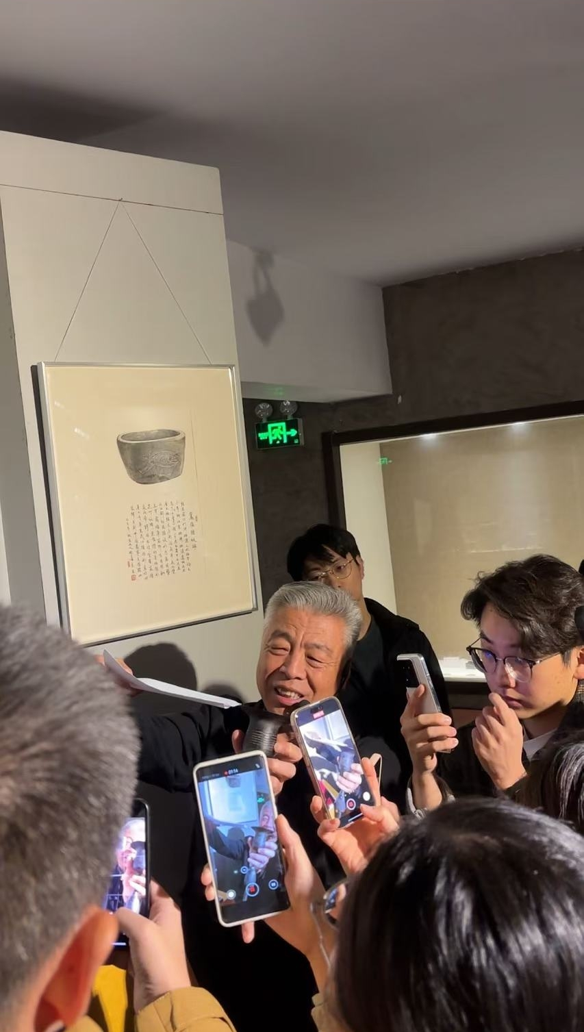 黑陶邢文化博物館館長邢葆東展示兩張相疊的A4紙，向記者解釋此為杯口的厚度。