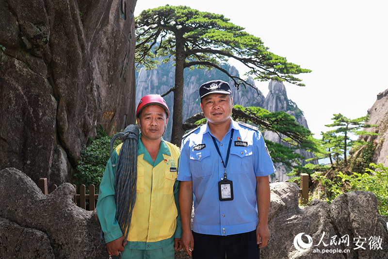 全國道德模范李培生（左）和胡曉春在迎客松前合影。人民網(wǎng)記者 張俊攝