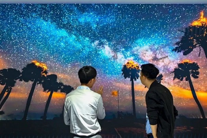 長春光博會希達電子展區(qū)，一位工作人員正在給一位觀眾講解。（長春新區(qū)供圖）