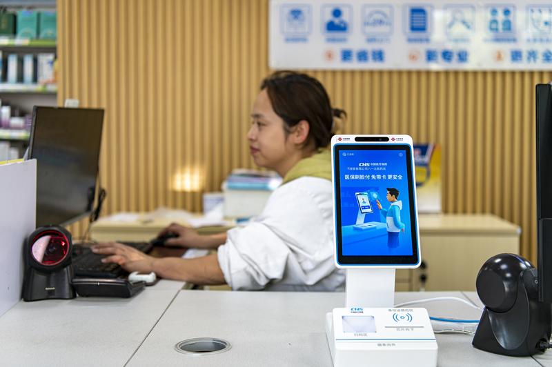 2024年4月10日，浙江金華市區(qū)一家民眾大藥房柜臺(tái)上設(shè)置著醫(yī)?！八⒛樦Ц丁睓C(jī)器，群眾看病更加便利。