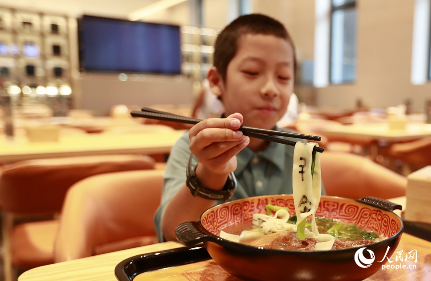 殷墟博物館推出的甲骨文面深受游客喜愛。人民網(wǎng)記者 慎志遠 攝