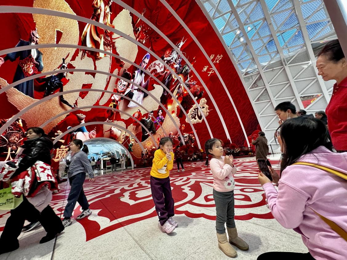 乙巳蛇年春節(jié)期間，影迷在《哪吒之魔童鬧海》巨幅海報前拍照打卡。