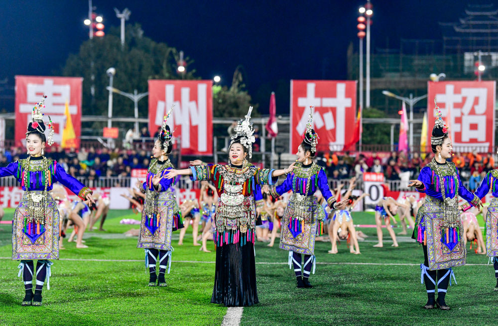 2025年3月14日，2025年貴州“村超”40強交叉賽在榕江“村超”足球場舉行，演員在比賽間隙表演侗族大歌，民族文化伴隨著體育賽事成功“出圈”。圖片來源：新華社