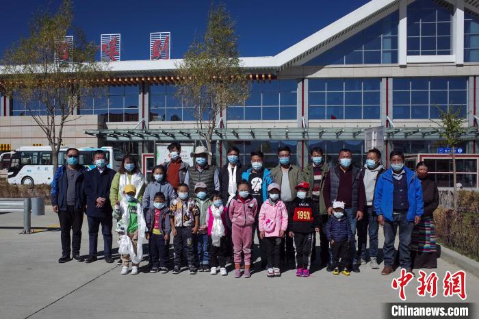 10位接受先心病治療的孩子及家長、工作人員等在日喀則和平機場合影?！〗w波 攝