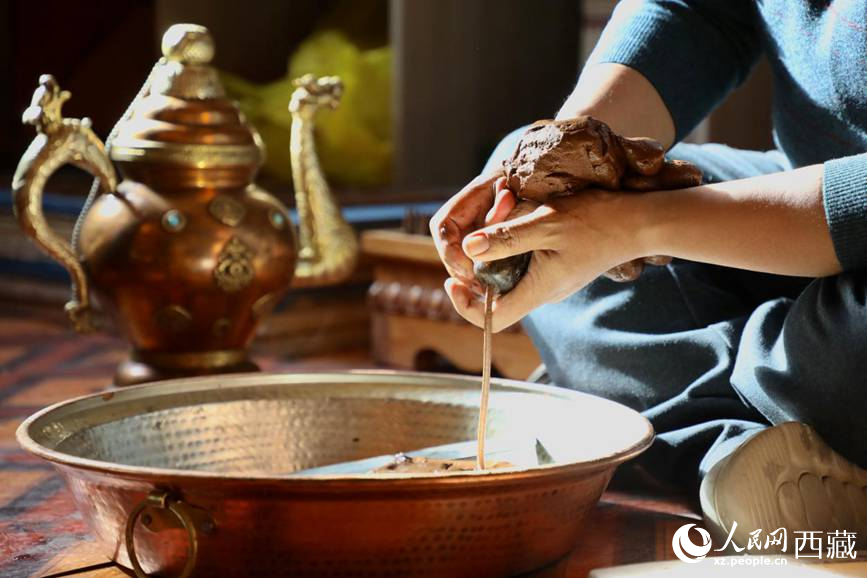 牛角鉆孔，將木泥擠出。人民網(wǎng)記者 次仁羅布攝