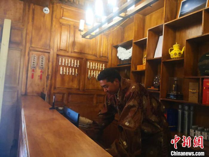 圖為桑杰才讓用電腦處理財務(wù)?！∈缝o靜 攝