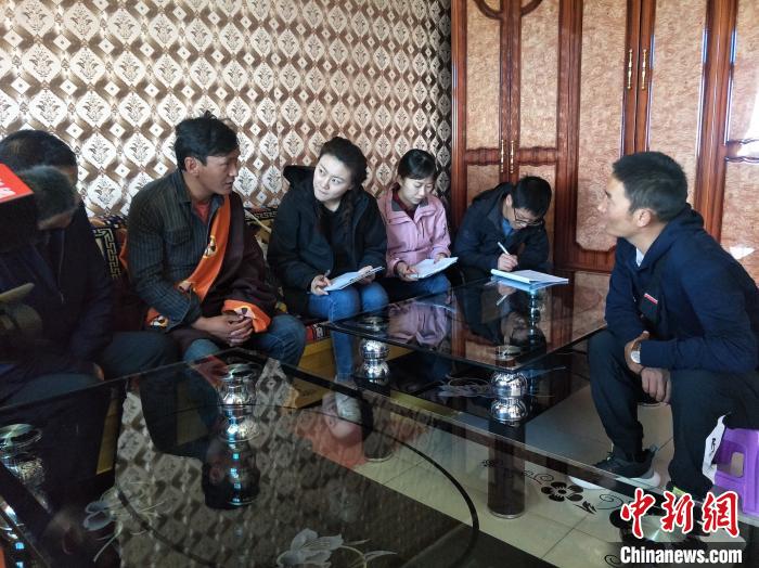 圖為調(diào)查組工作人員正在入戶調(diào)查?！∑钤鲚?攝