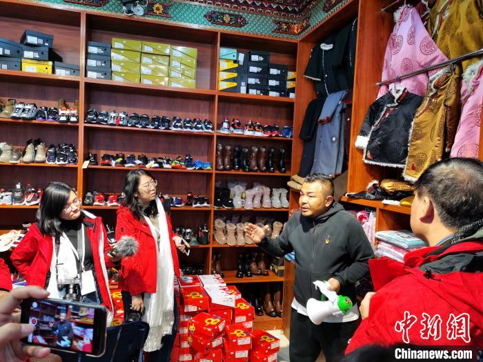 圖為中外媒體在玉樹州玉樹市甘達(dá)村采訪?！?zhí)砀?攝