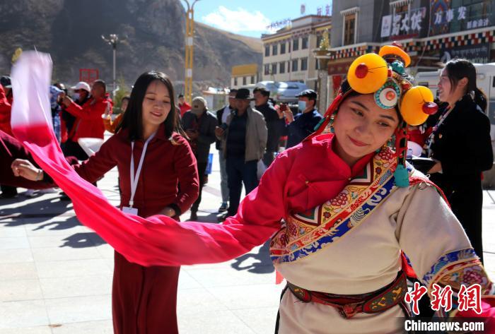 圖為中外記者向當(dāng)?shù)孛癖妼W(xué)習(xí)民族歌舞文化。　張?zhí)砀?攝