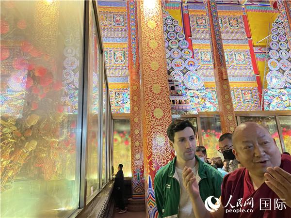 7月25日，省級非物質(zhì)文化遺產(chǎn)項目塔爾寺酥油花的代表性傳承人朋措堅參（右）在塔爾寺酥油花館講解酥油花的制作過程。人民網(wǎng) 謝瑩攝