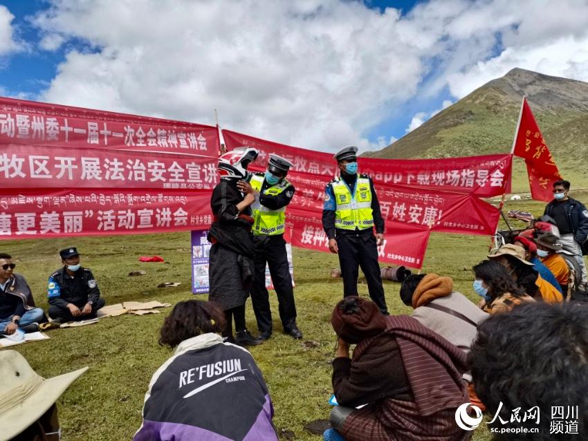 給牧民講如何佩戴安全頭盔。巴登攝