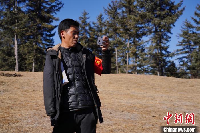 圖為桑杰加進(jìn)行巡查并拍照記錄?！●R銘言 攝