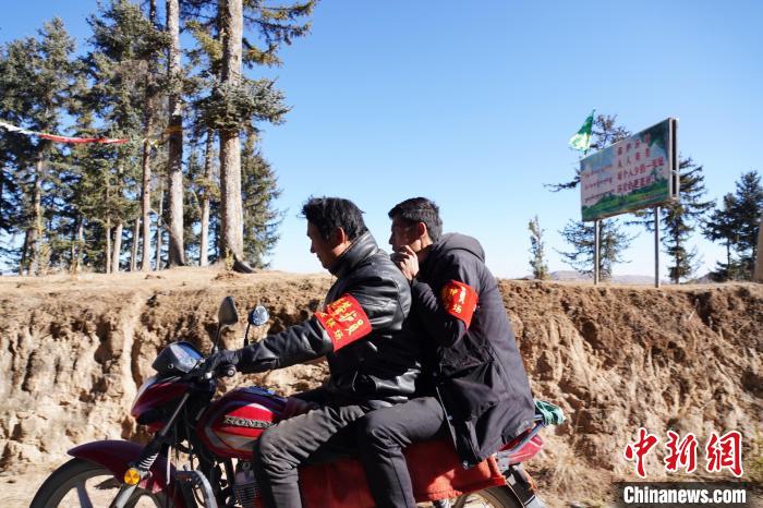 圖為同事騎摩托車載著桑杰加(后)前往林場(chǎng)。　馬銘言 攝