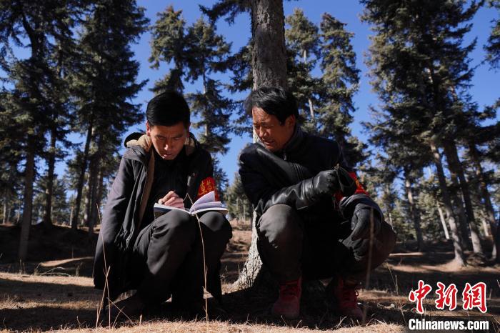 圖為桑杰加(左)和同事記錄巡查結(jié)果?！●R銘言 攝