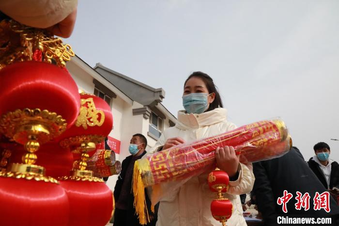 27日，蘭州新區(qū)為舟曲避險搬遷移民送“春節(jié)包”，楊周馬草前往領(lǐng)取，紅色寓意來年的日子紅紅火火。　魏建軍 攝