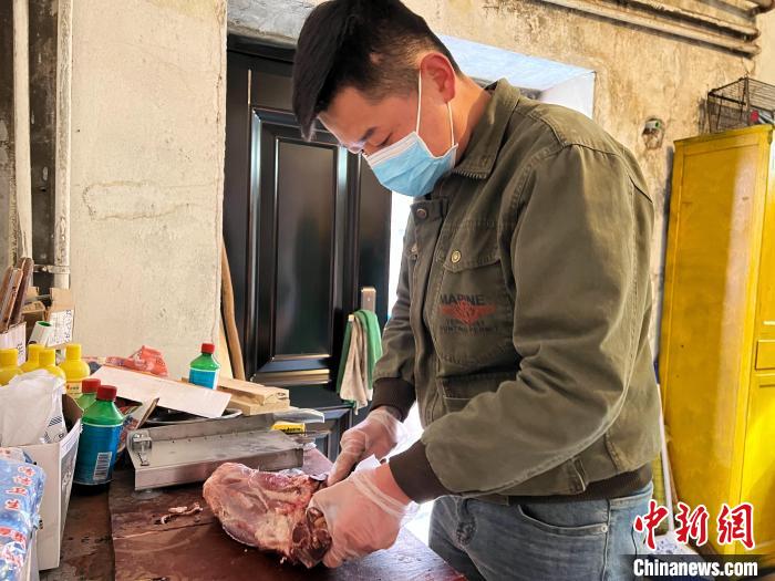 圖為雪豹“奶爸”史壽軍正在準(zhǔn)備投喂雪豹的食材?！●R銘言 攝