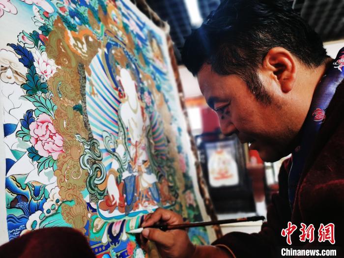 圖為久美尖措創(chuàng)作唐卡。　張?zhí)砀?攝