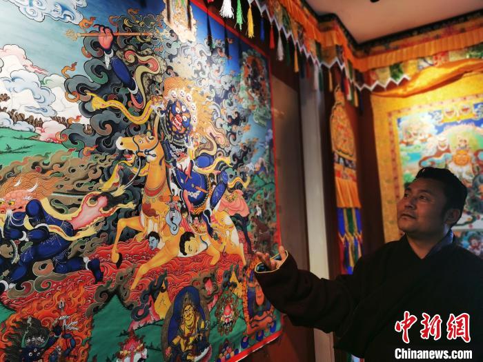 圖為久美尖措展示唐卡作品。　張?zhí)砀?攝