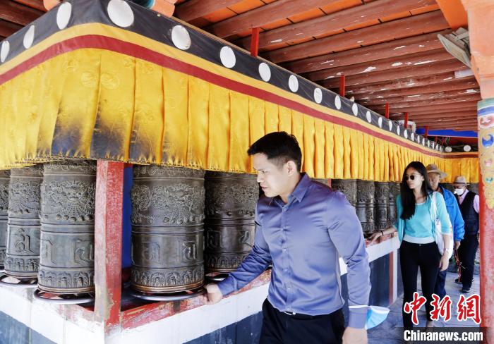 圖為外籍嘉賓體驗藏族傳統(tǒng)轉經(jīng)筒?！●R銘言 攝
