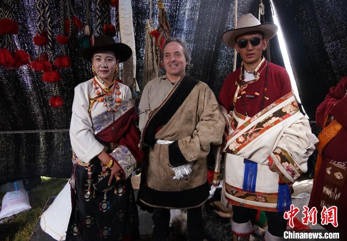 圖為一名外籍?dāng)z影師(中)身穿藏服和藏族民眾合影留念。　馬銘言 攝