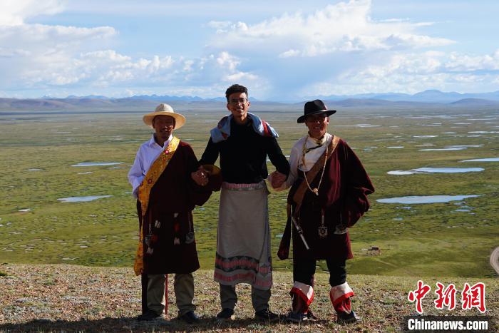 圖為一名留學(xué)生身穿自己國(guó)家的服飾和藏族民眾合影留念?！●R銘言 攝