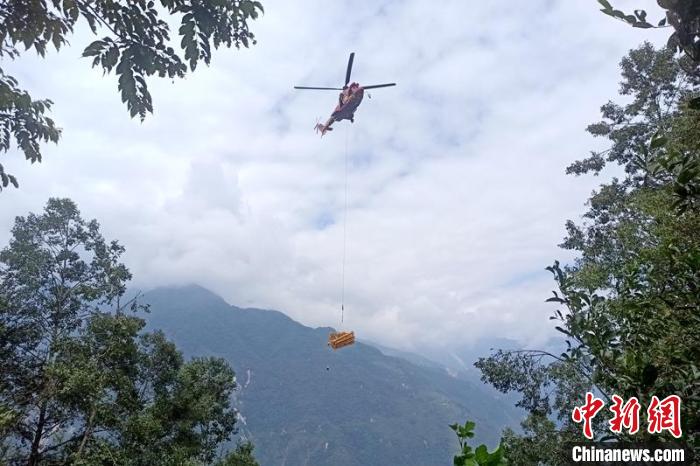 直升機起飛將搶修塔材運往海拔1950米的110千伏唐下線29號塔位。　徐慶明 攝