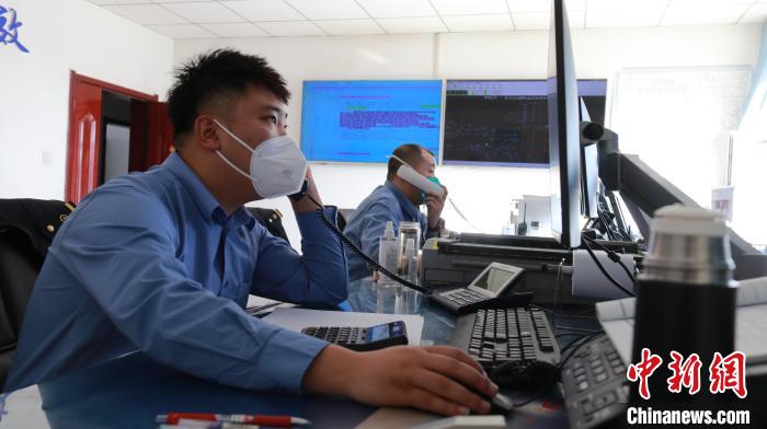 圖為貨運(yùn)調(diào)度人員與外勤工作人員聯(lián)系掌握車輛裝載情況。　李生燕 攝