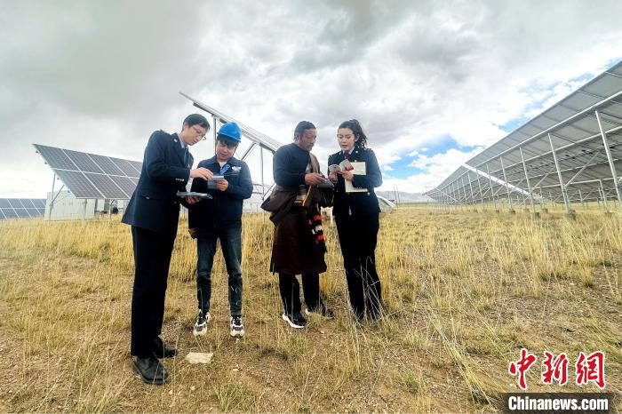 圖為稅務(wù)干部上門開展稅費輔導(dǎo)?！》劫F龍 攝