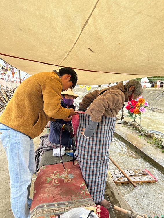 扎西奪爾登為路邊老人送去保暖圍腰。阿壩州文明辦供圖