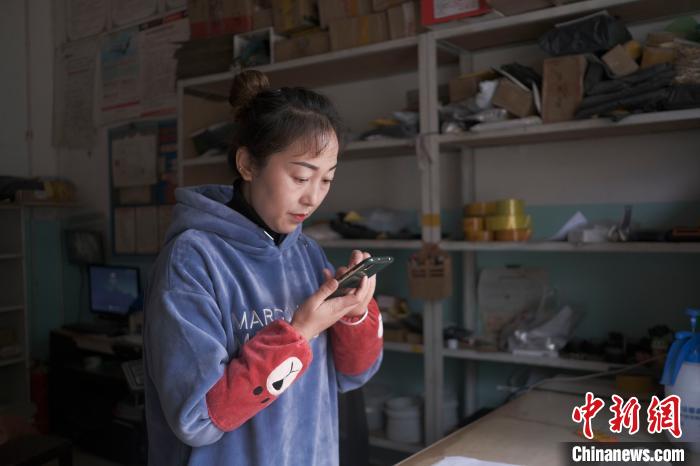 正在快遞站點(diǎn)內(nèi)忙碌的楊莉春。　何蓬磊 攝