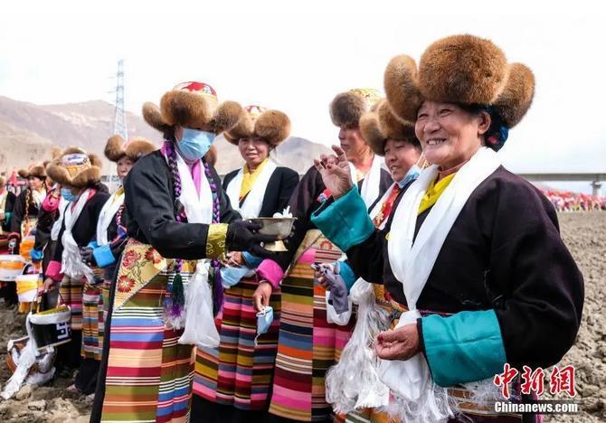 資料圖：西藏自治區(qū)拉薩市曲水縣才納鄉(xiāng)協(xié)榮村參加春耕儀式的村民互敬青稞酒。按照傳統(tǒng)，當(dāng)?shù)卮迕裆碇?jié)日盛裝，舉行隆重的儀式，祈福一年的豐收。<a target='_blank' ><p  align=