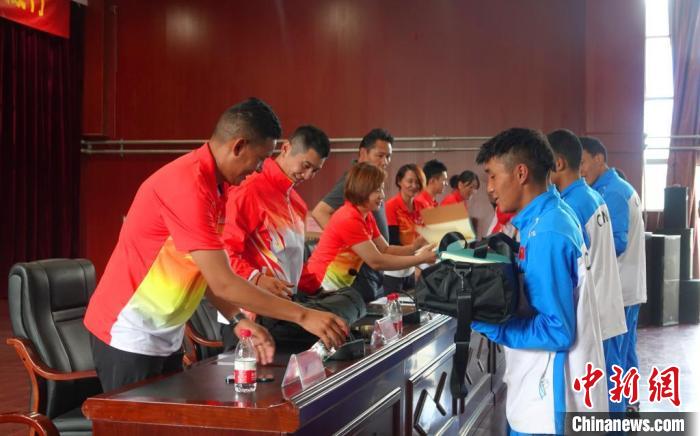 圖為世界冠軍們?yōu)槲鞑刈灾螀^(qū)體校的學(xué)生們送上暖心物資。　冉文娟 攝